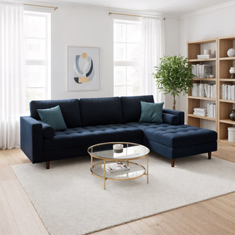 Claude 3-Seater Velvet Sofa with Chaise in Navy Blue, featuring plush upholstery and a chaise section, sits on a plush rug with teal pillows, enhancing the modern living room's elegant, cozy ambiance.