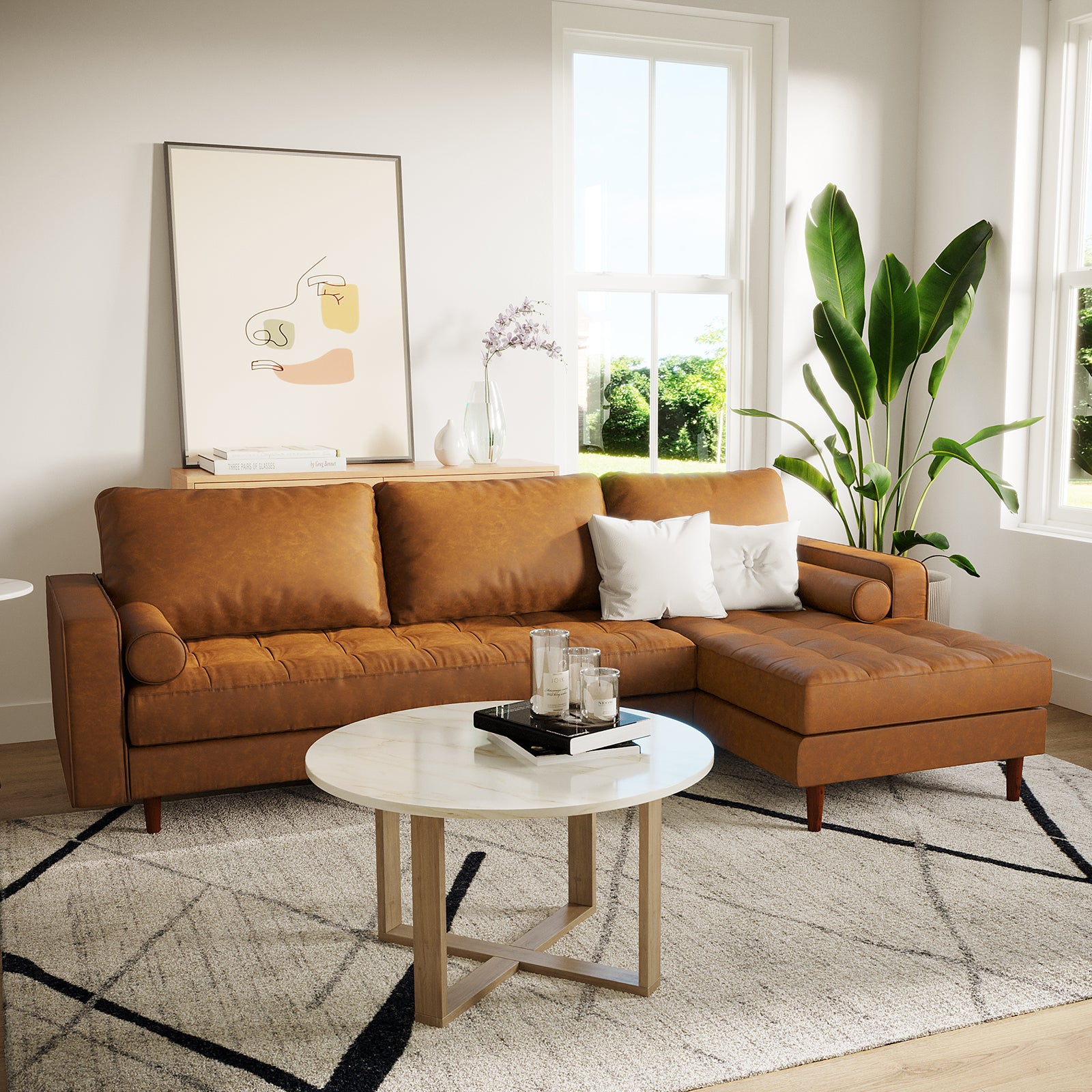 Claude 3 Seater PU Leather Sofa with Chaise in Tan Brown, featuring tufted cushions, two white pillows, and a sleek, L-shaped design, is set in a stylish, naturally-lit living room.