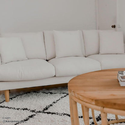 Colton Fabric 3 Seater Sofa Cream White displayed with a white pillow, showcasing its clean lines and soft cushions, perfect for modern living rooms.