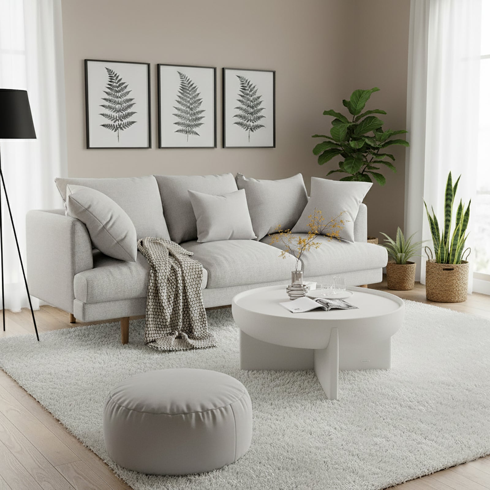 Colton 3-Seater Fabric Sofa in Stone, featuring light-gray upholstery with matching cushions, set in a bright, minimalist living room with botanical prints, a shag rug, and floor-to-ceiling window.