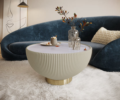 Cozy living room with Colton Living Room Package in Cream White, featuring a round coffee table with decorative vases, a curved blue velvet sofa, and a warm pendant light above.