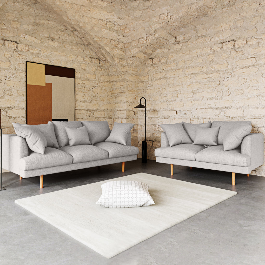 Colton 5-Seater Fabric Sofa in Stone nestled in a minimalist living-room corner with mid-century style, featuring sleek lines and plush cushions, complemented by a black floor lamp and abstract artwork.