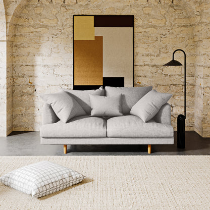  Colton 2 Seater Fabric Sofa Stone, highlighting its sleek design, soft cushions, and solid wood frame, showcasing modern style and comfort in a cozy indoor setting.