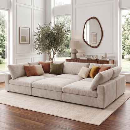 Beige sectional sofa styled in a bright modern living room with pillows and decor.