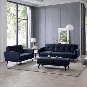 Esben Velvet Fabric Ottoman in Navy Blue, featured in a modern living room, showcases a plush, rectangular design with Scandinavian-style wooden legs, positioned on a light-grey rug.