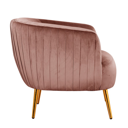 Evelyn Curved Velvet Sofa Accent Chair in Blush features a barrel-style design with vertical channel-tufted detailing and gold-tone tapered legs, adding elegance and comfort to any room.