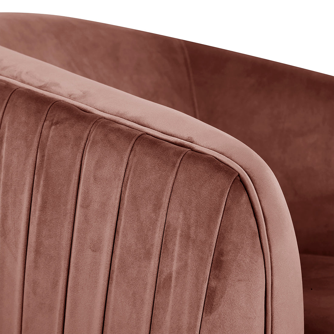 Close-up of Evelyn Curved Velvet Sofa Accent Chair in Blush, featuring plush velvet upholstery with vertical channel stitching, highlighting its modern tufted design and elegant, curved arm and side panel.