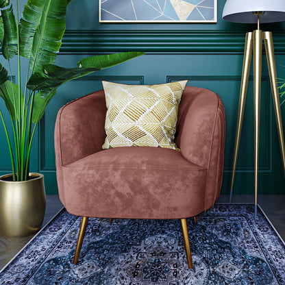 Evelyn Curved Velvet Sofa Accent Chair in Blush, featuring a warm terra-cotta velvet upholstery, square geometric pillow, and gold-accent legs, set in a cozy, stylish living room corner.