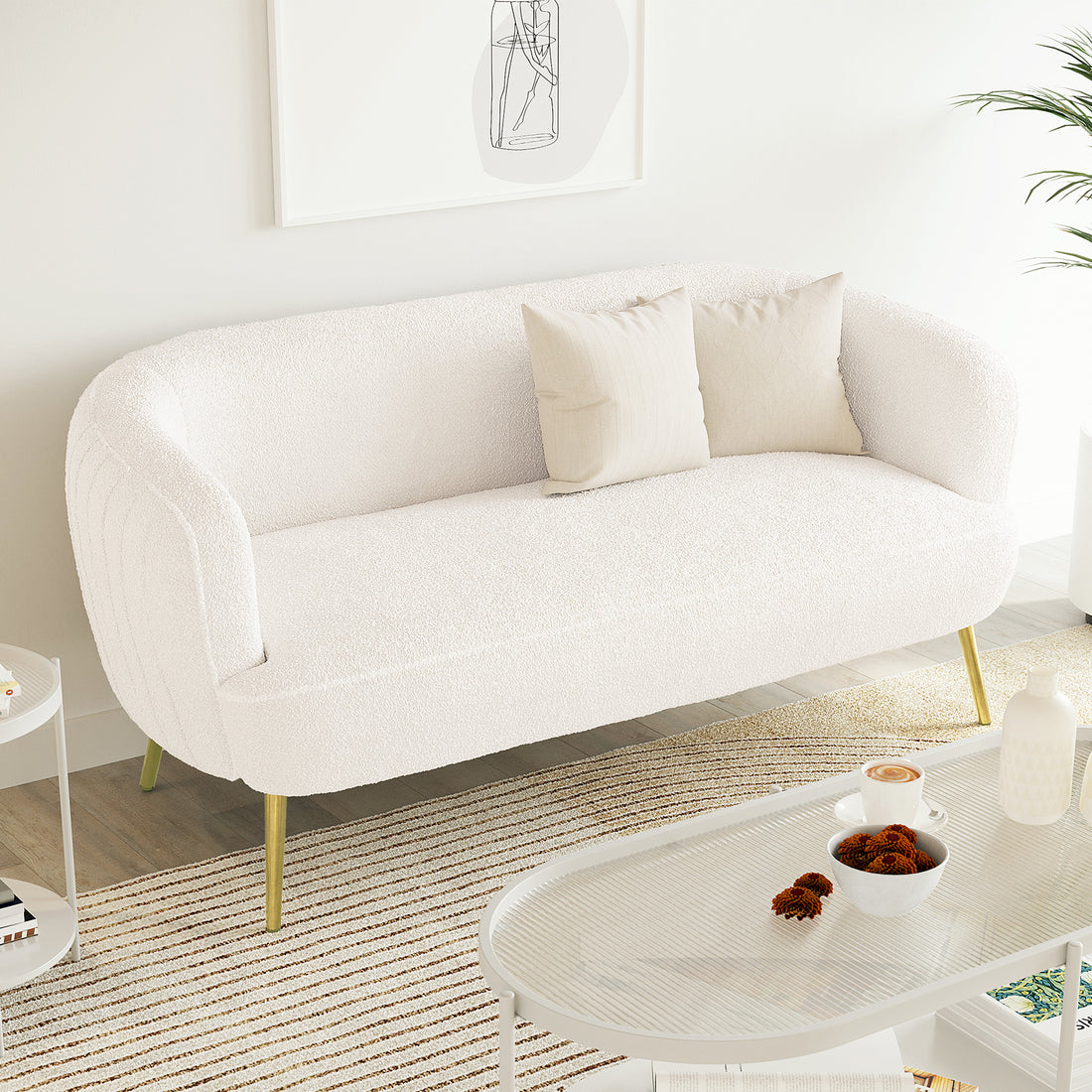 Evelyn 2 Seater Curved Boucle Sofa in Cream White, featuring a low, elegant design with slim brass-tone legs, adorned with two linen cushions, set in a minimalist Scandinavian-style living area.