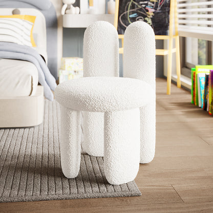 Flore Boucle Kids Chair with Bunny Ears in Cream White, featuring a playful bunny-shaped backrest and soft boucle upholstery, sits on a rug in a child's bedroom, surrounded by books and toys.