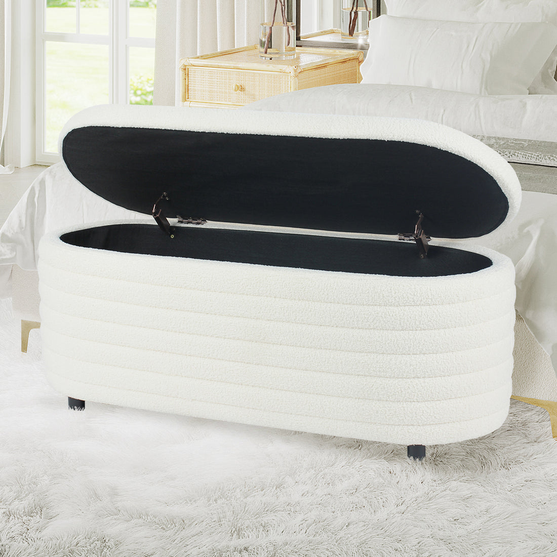 Hartwin 114cm Boucle Ottoman with Storage - Cream White, featuring a white upholstered lift-top design at a bed's foot, open to show a black-lined storage space for bedroom items.