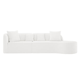 Hattie 4 Seater Boucle Sofa in Cream White features a modern, modular design with a low backrest, curved chaise lounge, and matching throw pillows, all upholstered in textured bouclé fabric.
