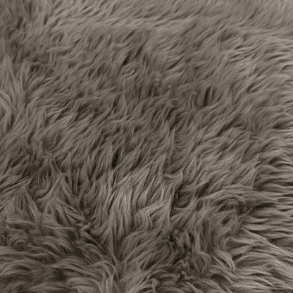 A macro close-up texture view of the taupe faux-fur or sheepskin material, showing the dense, long-pile fibers.