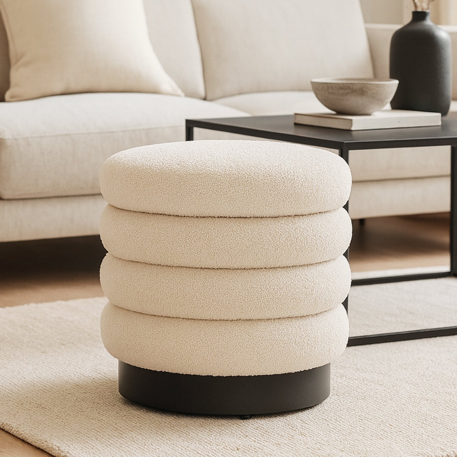 Irina Boucle Round Ottoman Footrest Stool in Cream White, featuring a plush boucle upholstery, ribbed design, and sturdy metal base, set in a minimalist living room with modern decor elements.