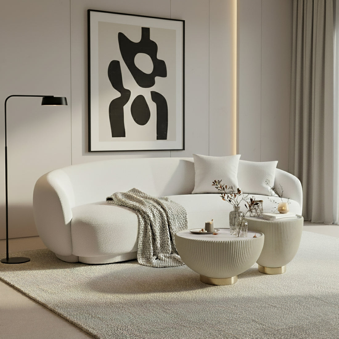 Janelle 213cm Curved Bouclé 3.5-Seater Sofa in Cream White, featuring plush throw pillows, a beige knitted blanket, and a solid wood frame, set in a minimalist living area.