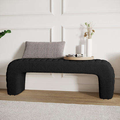 Josie Curved Boucle Fabric Bench Seat in Black, featuring a U-shaped design, black boucle upholstery, with a gray lumbar pillow, two ceramic vases, and a wooden tray with decor items.
