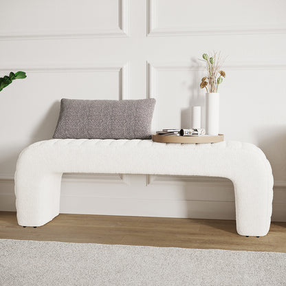 Josie Curved Boucle Fabric Bench Seat in Cream White features a U-shaped design with a textured gray lumbar pillow and a round wooden tray with vases and papers.