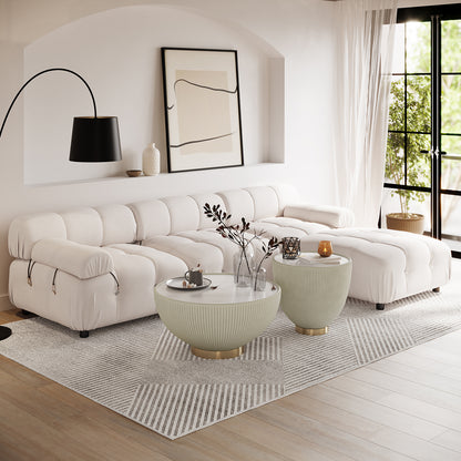 Keila 3 Seater Modular Tufted Sofa with Ottoman in Cream, featuring low-profile tufted design, set in a bright living room with ribbed coffee tables, arc floor lamp, and sheer drapes.