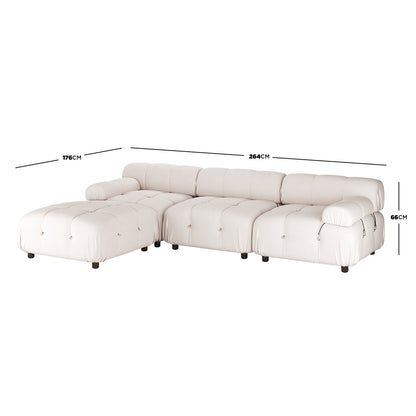 Keila 3 Seater Modular Tufted Sofa with Ottoman in Cream features a low-profile L-shape, tufted cushions, rounded armrests, and dark short cylindrical legs, measuring 264cm by 176cm by 66cm.