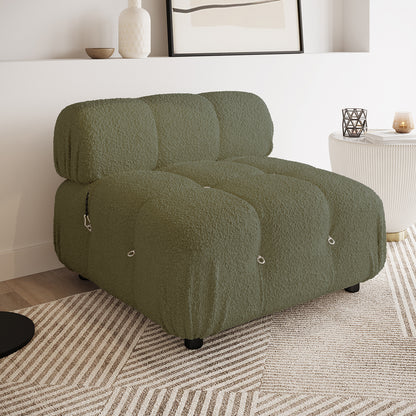 Keila Modular Tufted Boucle Single Sofa in Green, featuring large tufted sections with metal eyelets and clips, sits on a geometric-patterned rug beside a white side table with decor.