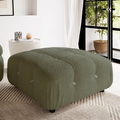 Keila Modular Tufted Boucle Ottoman in Green, featuring deep olive-green boucle upholstery, tufted nine-section design, and metal ring details, centered on a striped rug with a side table nearby.