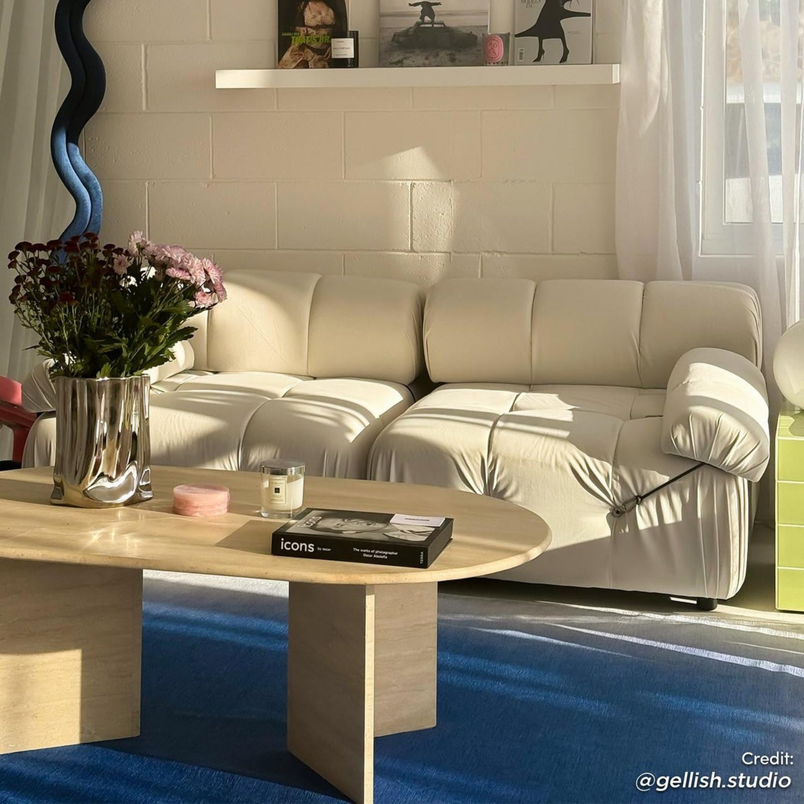Keila 2 Seater Modular Tufted Sofa Set in cream velvet, nestled in a sunlit corner with a travertine coffee table, sculptural vase, and deep blue rug, exuding elegance and comfort.