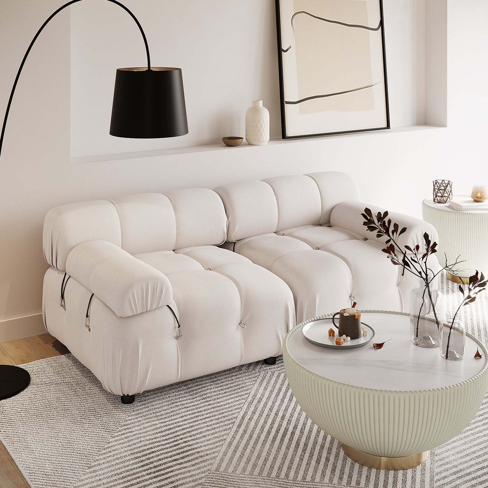 Keila 2 Seater Modular Tufted Sofa Set in Cream Velvet sits in a minimalist living room, paired with a curved floor lamp, ribbed coffee table, and geometric rug, exuding contemporary elegance.