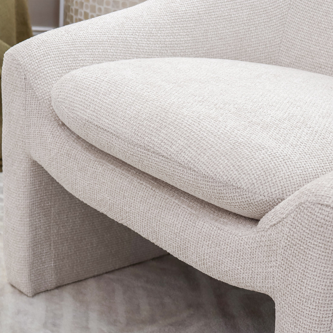 Close-up of the Kotrina Linen Chenille Accent Armchair showcasing its curved design and plush chenille upholstery, emphasizing the deep seating and ergonomic structure for ultimate comfort.