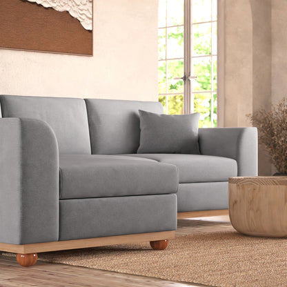 Close-up of the Laylah 3 Seater Fabric Hardwood Sofa With Left Chaise, showcasing its plush grey cushions and sturdy wooden frame, emphasizing comfort and style for modern interiors.