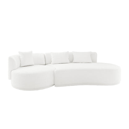 Lyana 4 Seater Boucle Sofa with Right Chaise in Cream White, featuring a modern, all-white curved design, textured boucle fabric, and four matching throw pillows for a sculptural look.