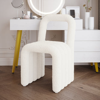 Lycus Boucle Cushioned Metal Frame Accent Chair Cream White, featuring a modern design with a cushioned seat, metal frame, and arched back, positioned next to a table indoors.