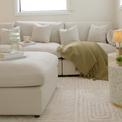 Millie 4-Seater Fabric Corner Chaise Sofa Light Beige on a couch with plush cushions, showcasing its deep seating and modular design, ideal for modern interior living spaces.