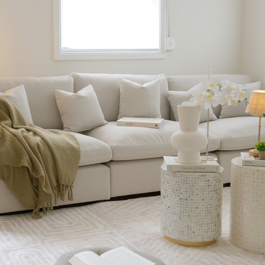 Millie 4-Seater Fabric Modular Sofa Light Beige with clean lines, deep seating, and removable cushions, showcased in a modern interior with a close-up of a white pillow on a couch.