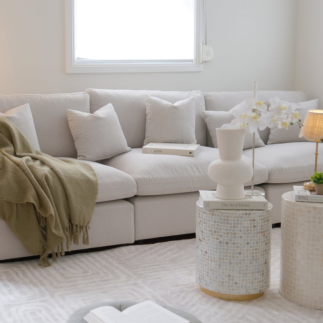 Millie 4-Seater Fabric Modular Sofa in warm light grey, shown with deep, plush cushions on a couch. The image highlights its modular design and stylish comfort ideal for relaxation or hosting guests.