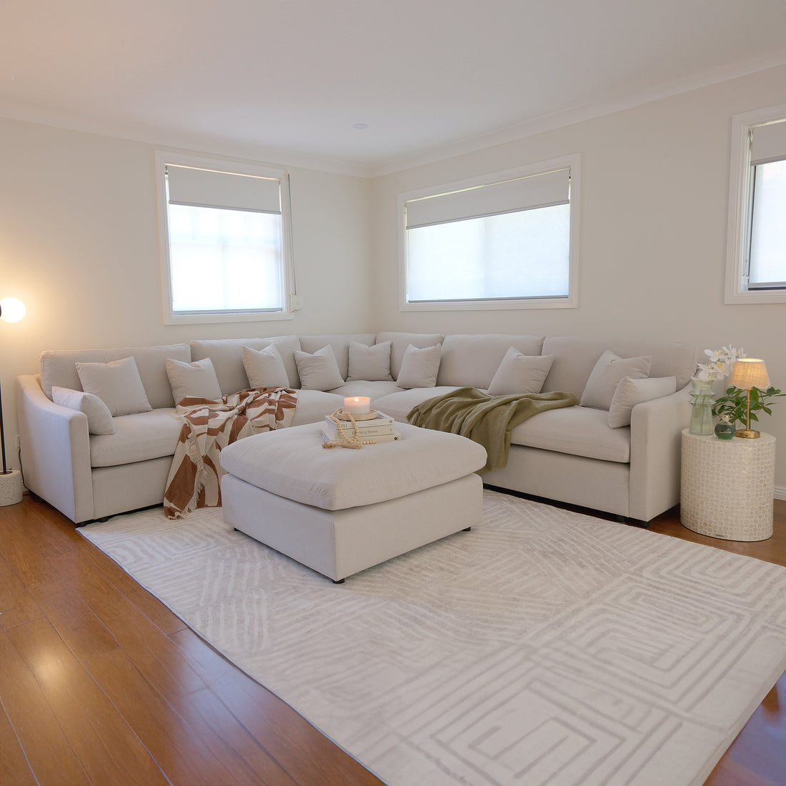 Millie 6-Seater Fabric Corner Chaise Sofa in warm light grey, showcased with plush cushions on a couch, highlighting its spacious modular design ideal for comfortable lounging or hosting.