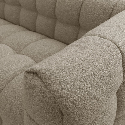 Close-up of the Norah 3 Seater Boucle Sofa in Warm Beige, highlighting the plush, tufted armrest and seat cushion in soft, textured boucle fabric, showcasing its modern design and inviting comfort.
