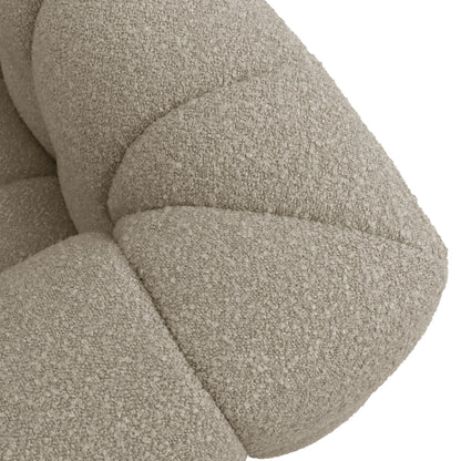 Norah 3 Seater Boucle Sofa in Warm Beige, showcasing close-up of cream-beige boucle fabric with visible tufted, padded segments. The textured looped upholstery highlights the sofa's contemporary, inviting aesthetic.