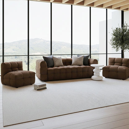 Norah 5-Seater Boucle Sofa Set with Armless Chairs in Chocolate Brown, featuring a tufted design, patterned throw pillows, and positioned beside a sculptural side table in a modern, window-lit living room.