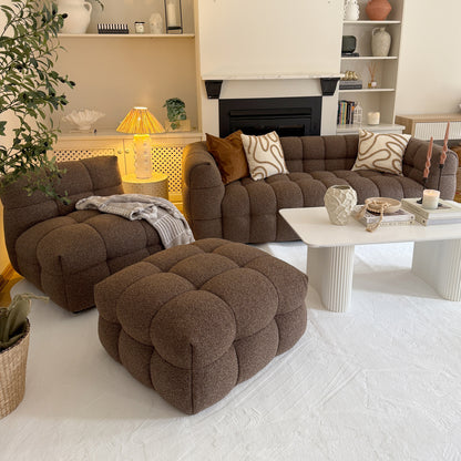 Norah 5 Seater Boucle Sofa Set With Ottoman in Brown, featuring tufted design, paired with a white coffee table and decorative items, set in a cozy, neutral-toned living room corner.