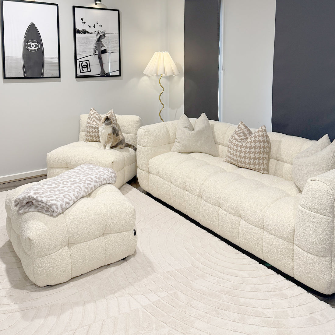 Norah 5 Seater Boucle Sofa Set with Ottoman in Cream White features a tufted design with matching ottoman, houndstooth-pattern pillows, and a light-beige blanket, creating a cozy, stylish living space.