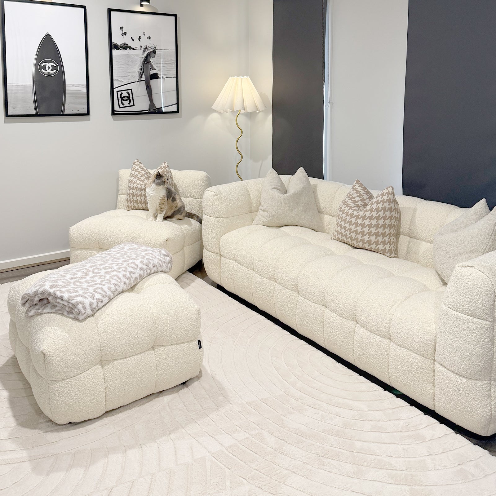 Norah 5 Seater Boucle Sofa Set with Ottoman in Cream White features a tufted design with matching ottoman, houndstooth-pattern pillows, and a light-beige blanket, creating a cozy, stylish living space.