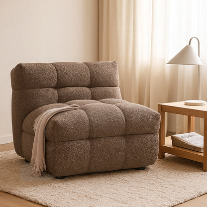 Norah Boucle Single Seater Sofa in Brown features a textured, tufted design with a draped throw, set on an off-white rug beside a wooden side table and lamp.