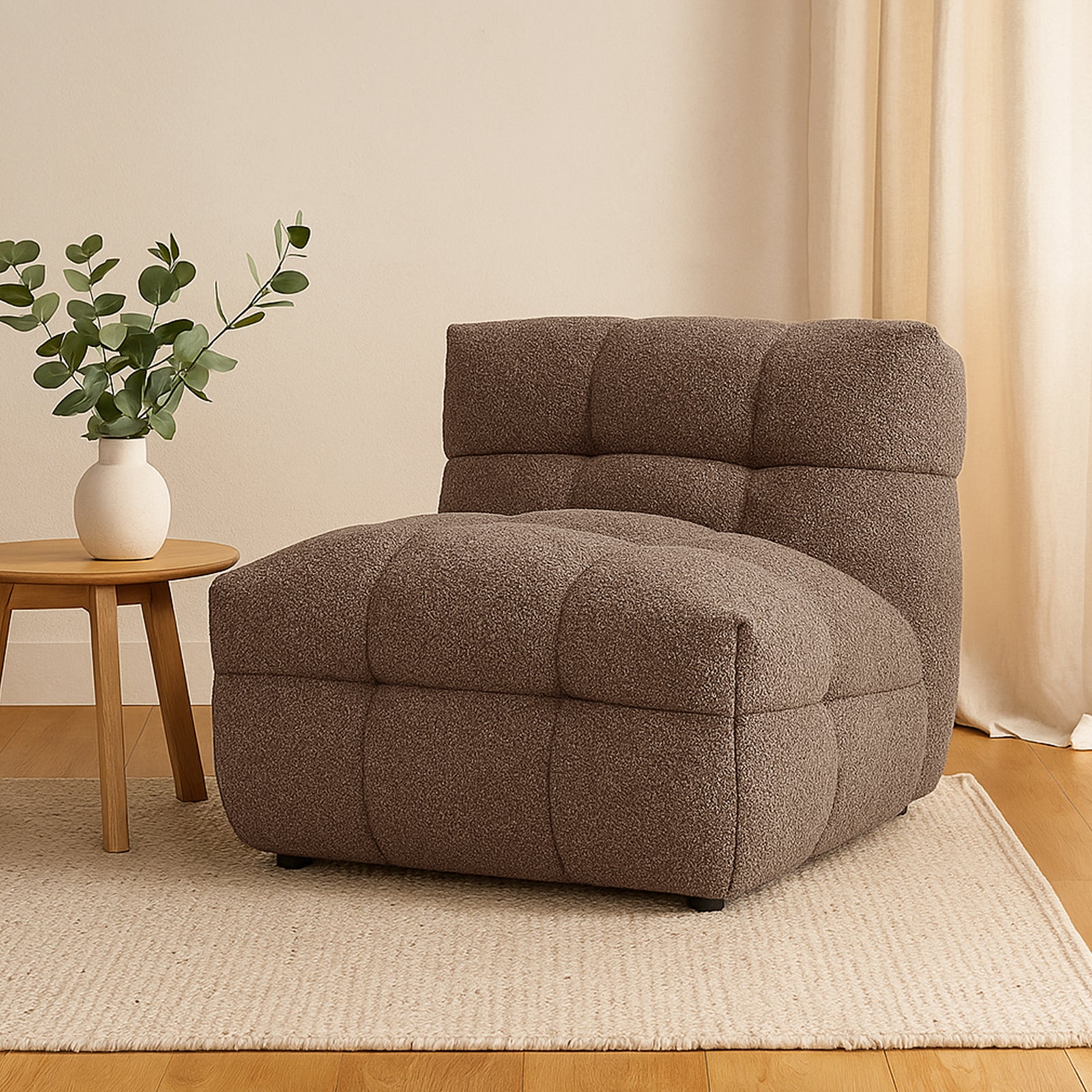 Norah Boucle Single Seater Sofa in Brown, featuring tufted upholstery, sits on a light-beige rug. A small wooden side table with a white vase complements the cozy, modern setup.
