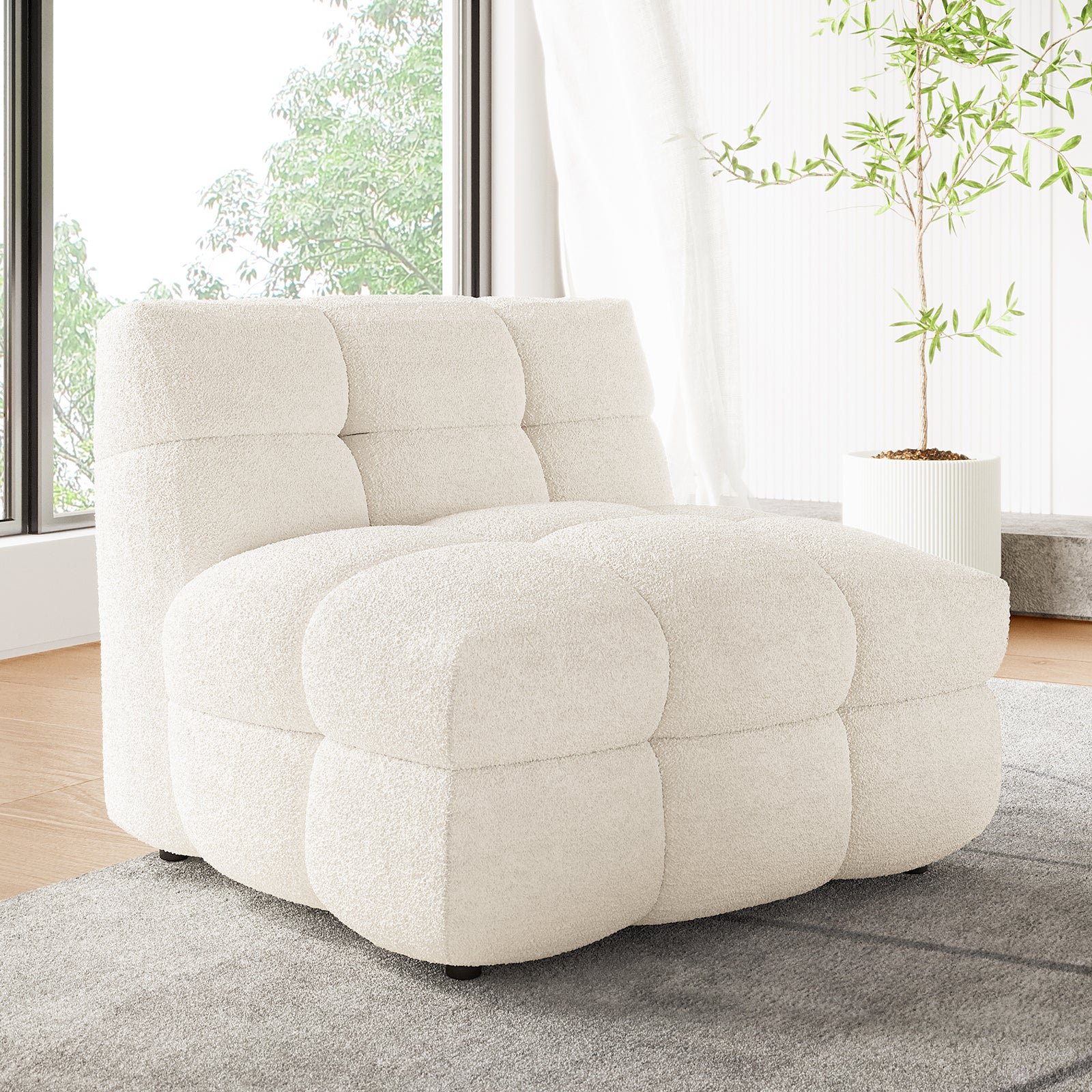 Norah Single Seater Boucle Sofa in Cream White with tufted, grid-patterned cushions, sits on a grey rug in a modern living space, accompanied by a tall potted plant.
