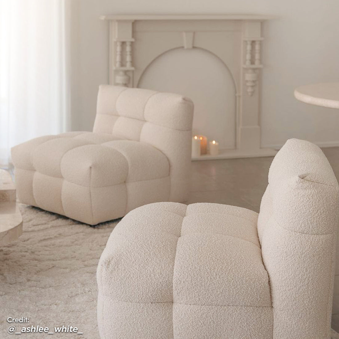 Norah Single Seater Boucle Sofa in Cream White, featuring a low-slung, tufted design, set in a cozy, minimalist living area with a textured rug and a round side table.