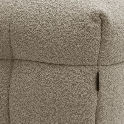 Close-up of the Norah Boucle Ottoman in Warm Beige, highlighting its soft boucle fabric texture around the seam and pocket area, showcasing its plush and sophisticated design.