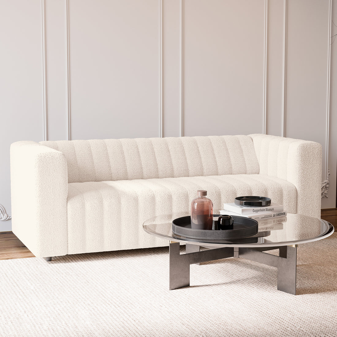 The Parisa 3 Seater Tufted Boucle Sofa in Cream White features a low-rise design with distinctive channel-stitching, upholstered in textured bouclé fabric, complementing a minimalist, elegant living area.
