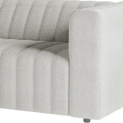 Close-up of Parisa 4 Seater Tufted Boucle Sofa Set in Light Grey, showcasing white textured bouclé fabric with vertical channel tufting and a small metal leg visible at the bottom.