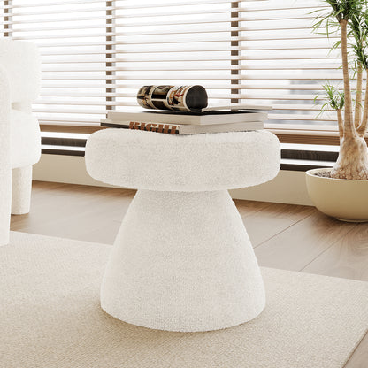 Sadi Bouclé Fabric Round Mushroom Ottoman in eggshell white, upholstered in soft bouclé fabric, serves as a stylish side table, set on a light-wood floor with a book and magazine on top.