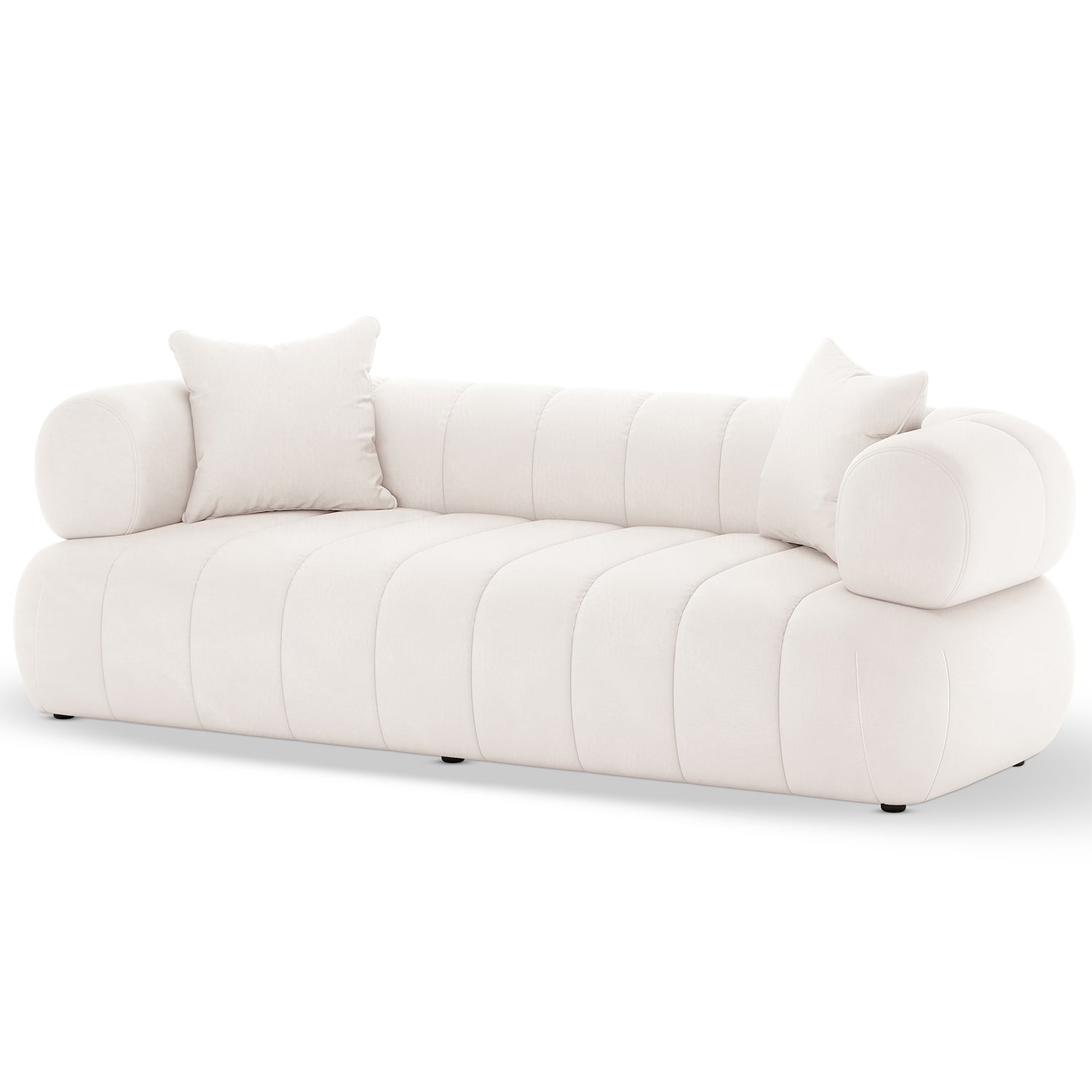 Samira 3 Seater Velvet Sofa in Cream, featuring a low-profile design with off-white velvet upholstery, rounded channel-stitched cushions, cylindrical bolster arms, and matching throw pillows, sits on small, discreet feet.